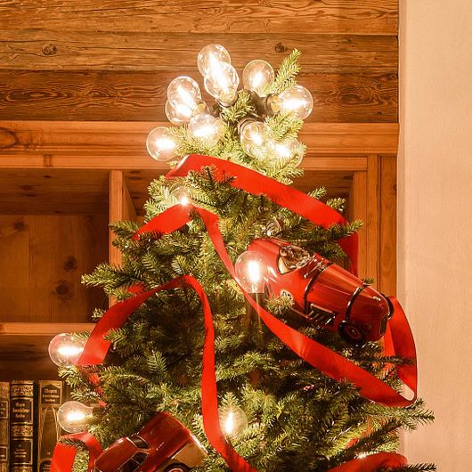 Catenaria di lampadine usata sulla cima di un albero di Natale con nastro rosso