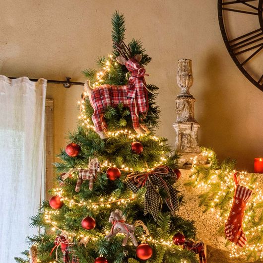 Renna in tessuto scozzese usata al posto del puntale su un albero di Natale