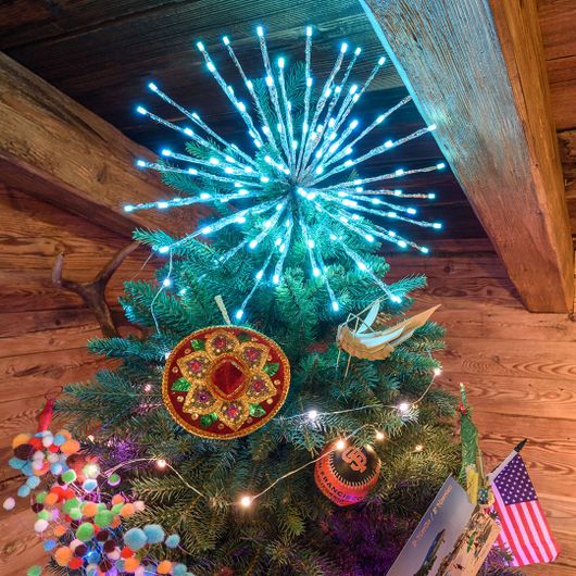 TwigBall a luce azzurra usata come puntale di un albero di Natale colorato